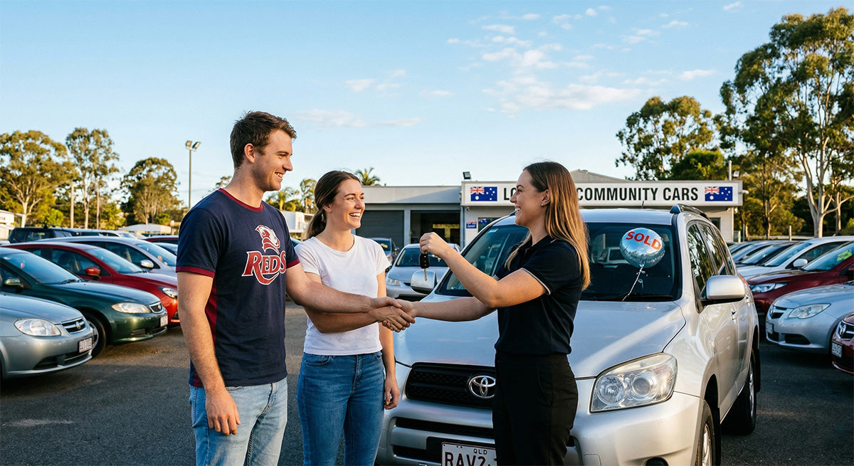 Happy young couple receiving keys to their new silver car